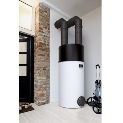 Aparelho cilíndrico branco com tubos pretos, parede de tijolos, porta preta e carrinho metálico