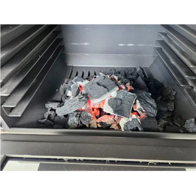 Grelhador a carvão com brasas acesas