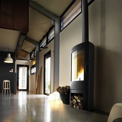 Lareira a lenha moderna preta com fogo visível num interior moderno com chão cinzento polido