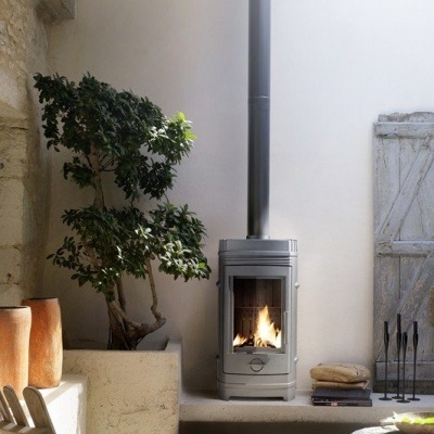 Lareira a lenha moderna numa sala rústica com planta verde e cadeira clara