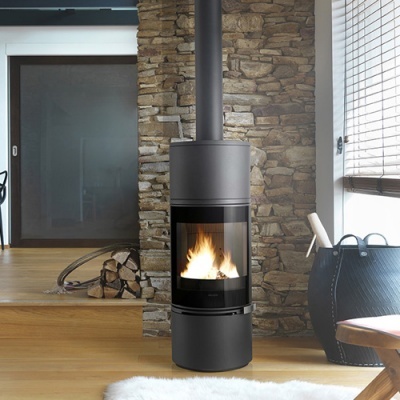 Lareira moderna preta com chaminé e fogo aceso junto a parede de pedra