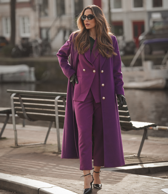 Casaco 500642 Mulher com conjunto roxo, luvas pretas e óculos escuros junto a canal urbano