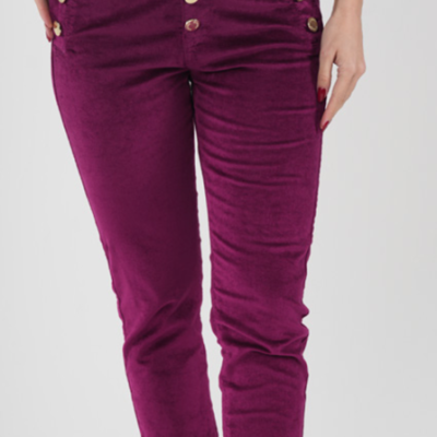Calças de veludo vinho com botões dourados numa modelo