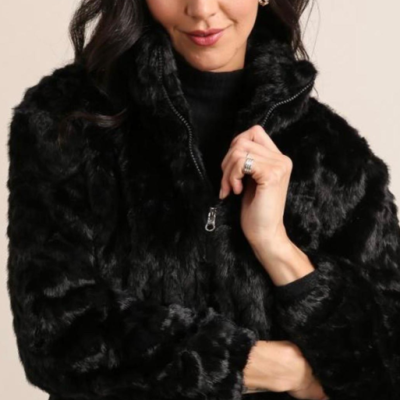 Mulher a usar casaco preto de pelo sintético com fecho de correr