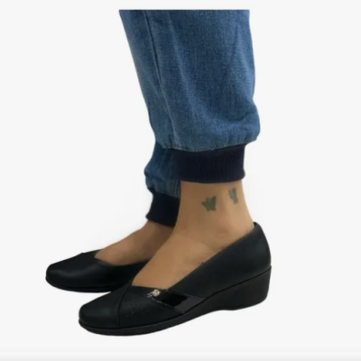 Sapatos pretos de cunha em pele com detalhe verniz na frente e calças de ganga azul