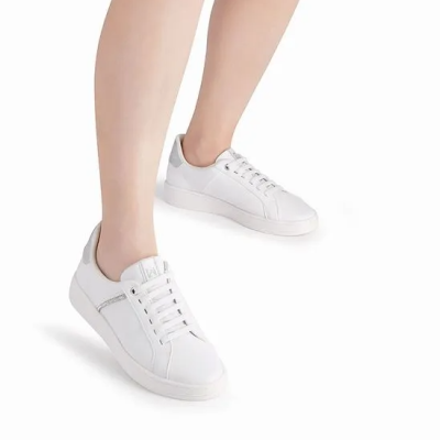 Ténis brancos em pele com detalhe prateado com fundo branco