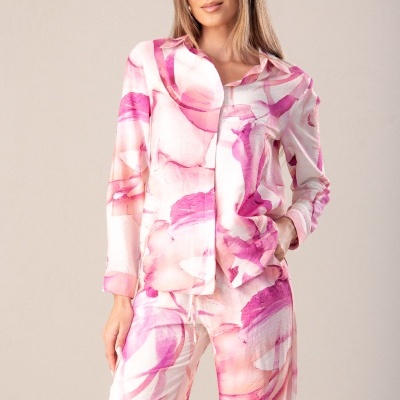 Conjunto feminino com padrão rosa, branco e lilás, camisa de manga comprida e calças largas.