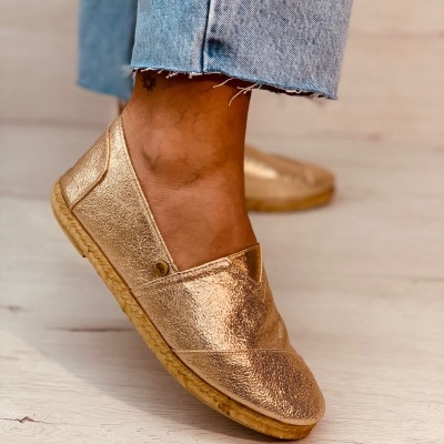 Sapatos planos dourados brilhantes com jeans azuis claros