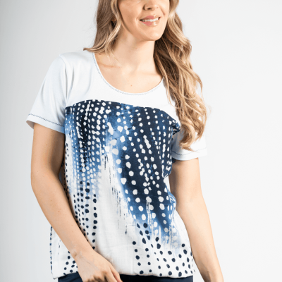 T-shirt feminina branca com padrão azul e branco e calças azuis em fundo branco