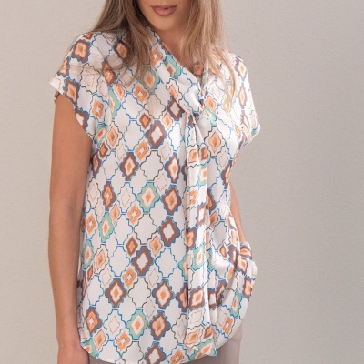 Blusa feminina de manga curta com padrão geométrico colorido e calças cinzentas