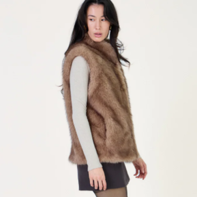 Colete castanho de pêlo sintético em mulher com roupa clara e saia preta