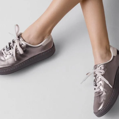 Par de sapatilhas metálicas cinza com sola preta e atacadores bege