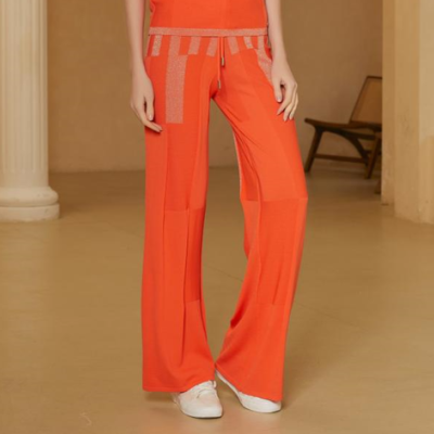 Calças largas laranja com detalhes texturizados e ténis brancos