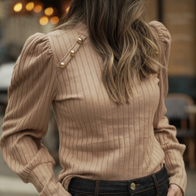 Camisola de malha bege com botões dourados e calças de ganga escuras