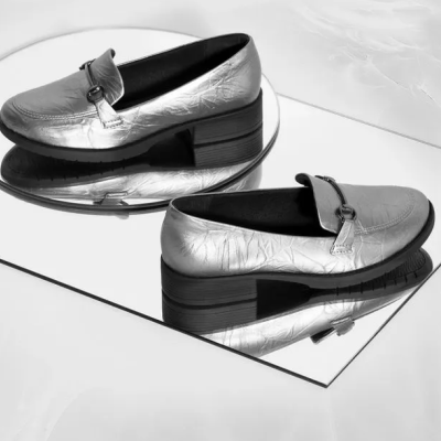 Sapatos prateados tipo mocassim sobre espelho