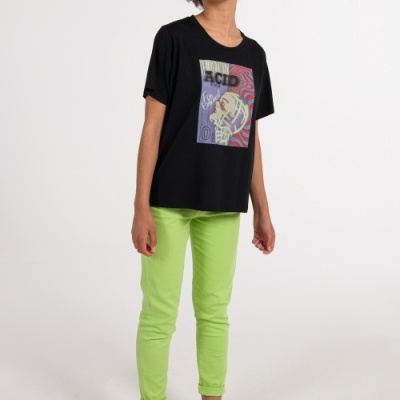 Pessoa com t-shirt preta estampada e calças verde-lima