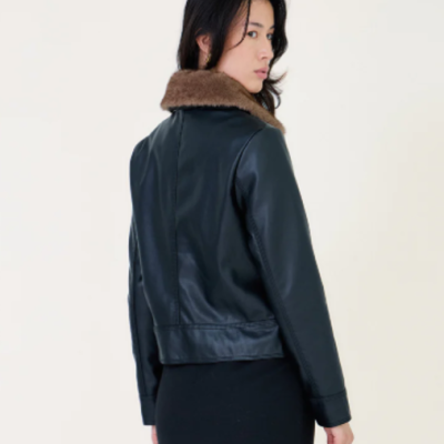 Casaco preto de pele com gola castanha em tecido tipo pêlo, usado por mulher