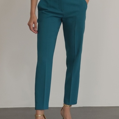 Calças azuis femininas de corte reto com bolsos, usadas com sandálias douradas de salto alto