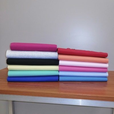 Pilha de tecidos coloridos dobrados sobre mesa de madeira