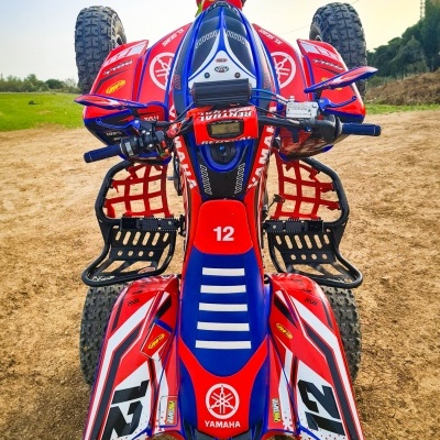 Quad YAMAHA vermelho, azul e branco com número 12 em terra batida