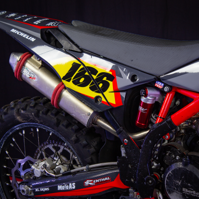 Motocross vermelha e preta com número 166 e marcas MICHELIN e LIQUI MOLY