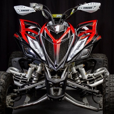 Quadriciclo vermelho, preto e branco com protetores de guiador brancos e pneus de borracha