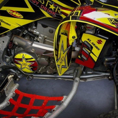 Detalhes de veículo todo-o-terreno com cores amarelo, vermelho e preto e textos visíveis