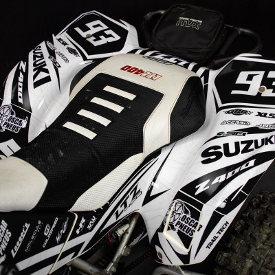 Veículo todo-o-terreno Suzuki branco e preto com várias etiquetas e número 93