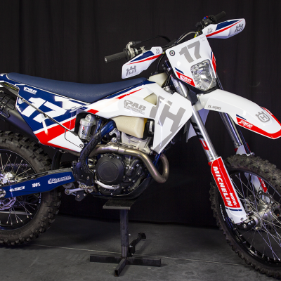 Motocross branca com detalhes em azul e vermelho, número 17, pneus Michelin, em base metálica