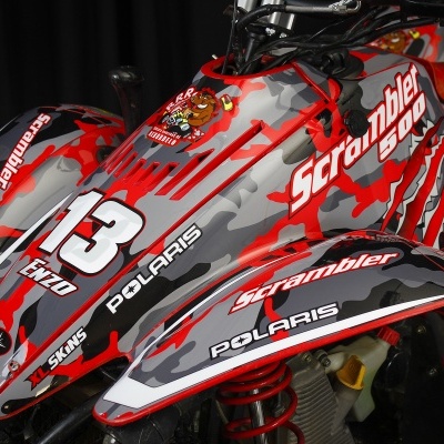 Todo-o-terreno camuflado vermelho, cinza e preto com texto e adesivos