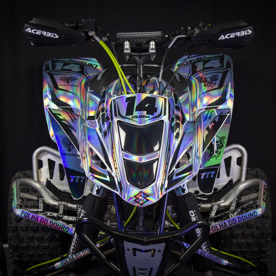 Quad prateado holográfico com número 14 e texto Suzuki, 777 e Folha do Douro em fundo preto.