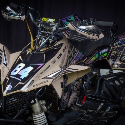 Quad Suzuki bege, preto e lilás com número 84 e pneus off-road