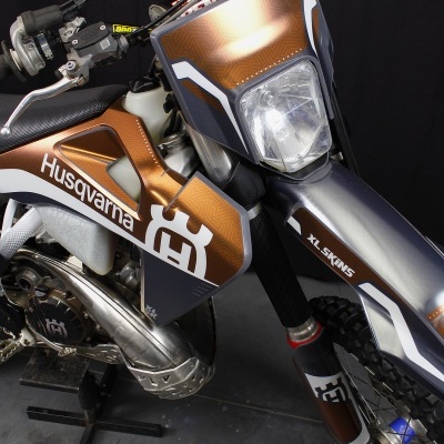 Motociclo Husqvarna cobre e preto com texto e farol quadrado