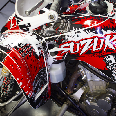 Veículo todo-o-terreno Suzuki com decoração gráfica em vermelho, branco e preto