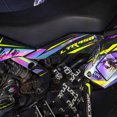 Lateral de mota com carenagem holográfica amarelo e roxo e assento preto