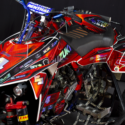 Quadro todo-o-terreno Suzuki vermelho, preto e branco com cadeado, número 14 e gráficos distintos