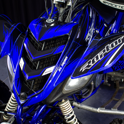 Quad todo-o-terreno azul com decalques Raptor e GYTR em preto e branco