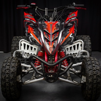 Quadriciclo vermelho e preto com pneus grossos e suspensão vermelha