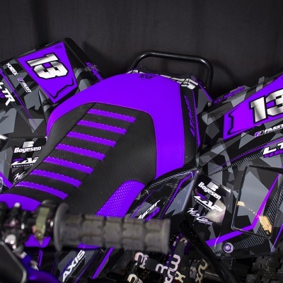 Veículo todo-o-terreno com plástico roxo e preto com o número 13