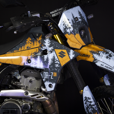 Motociclo Suzuki DR-Z 4S com gráfico laranja, cinzento e branco de árvores e logotipos