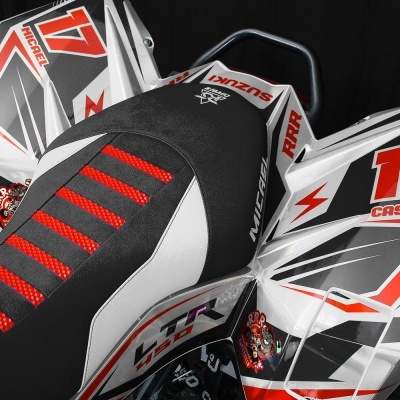 Assento e carenagens de mota com gráficos vermelhos, cinzentos e brancos, com textos VZR, PXR, CASTELOR e número 17