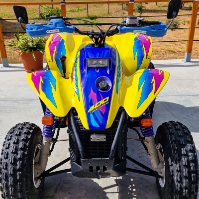 Quadriciclo amarelo com detalhes coloridos e portas-espelhos