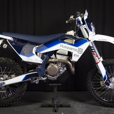 Motocross Husqvarna azul, branco e preto com texto e pneus de borracha