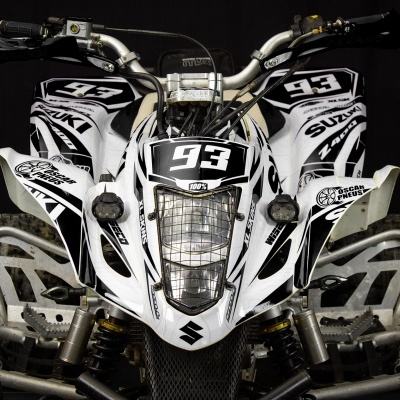 Quadriciclo Suzuki branco e preto com número 93 em fundo escuro