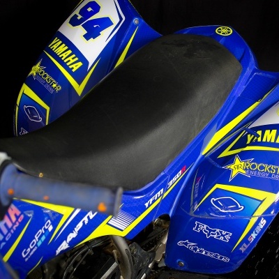 Motocicleta azul e amarela com número 94 e logotipos