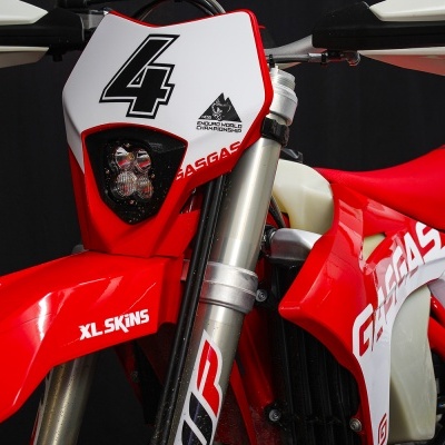 Motociclo de enduro vermelho e branco com número 4 no painel frontal e branding GASGAS
