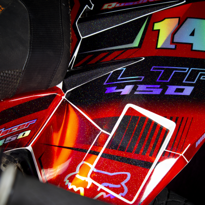 Parte lateral de mota vermelha e preta com número 14 e texto LTR 450