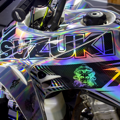 Depósito de moto Suzuki com acabamento holográfico prateado e detalhes gráficos em preto