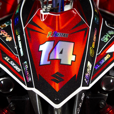 Frontal de mota vermelha, preta e branca com número 14 e autocolantes coloridos