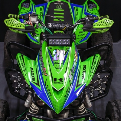 Quadriciclo Kawasaki verde e azul com proteções e inscrições visíveis